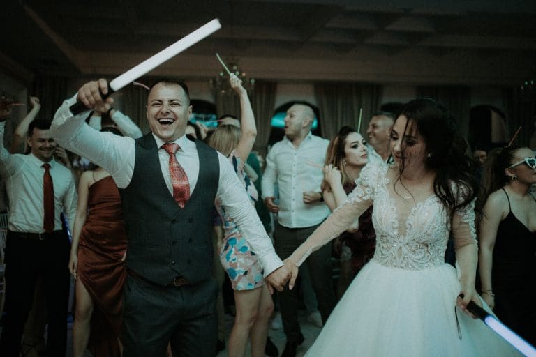 Miri și invitați dansând plini de energie pe ringul de dans la petrecerea de nuntă