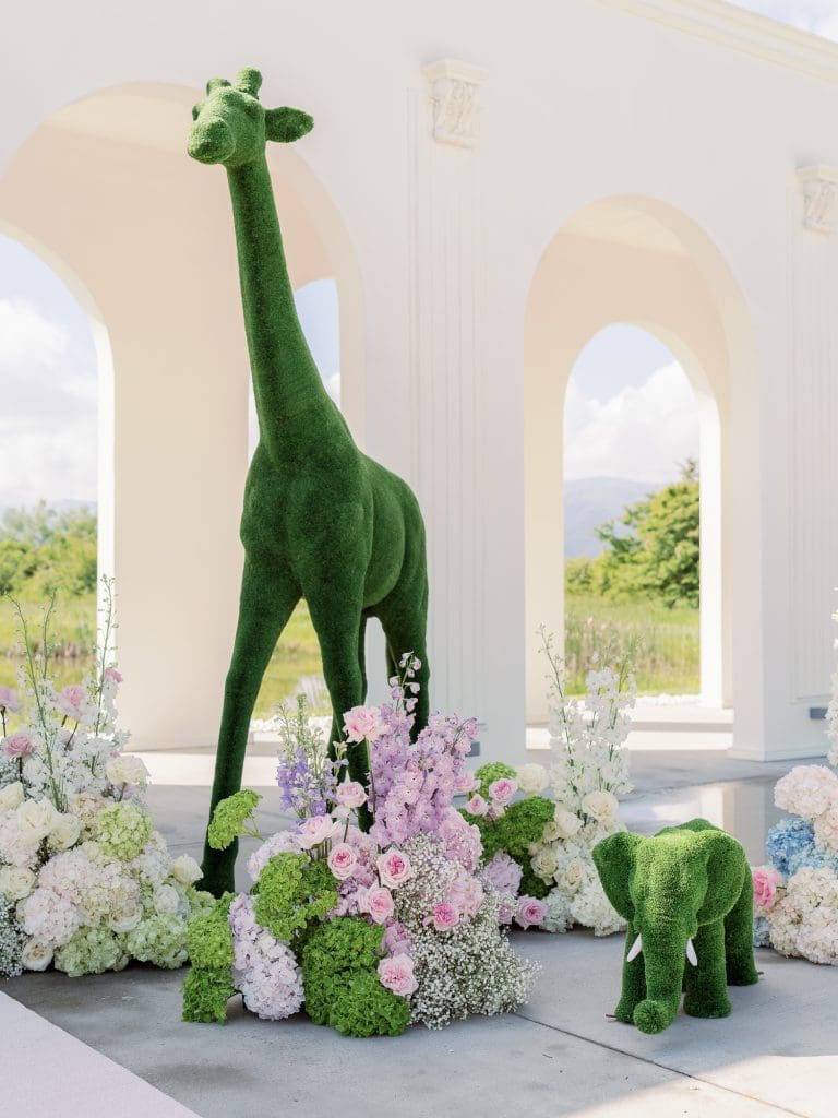 Decor creativ de styled shoot cu girafă topiară verde și flori pastelate de nuntă