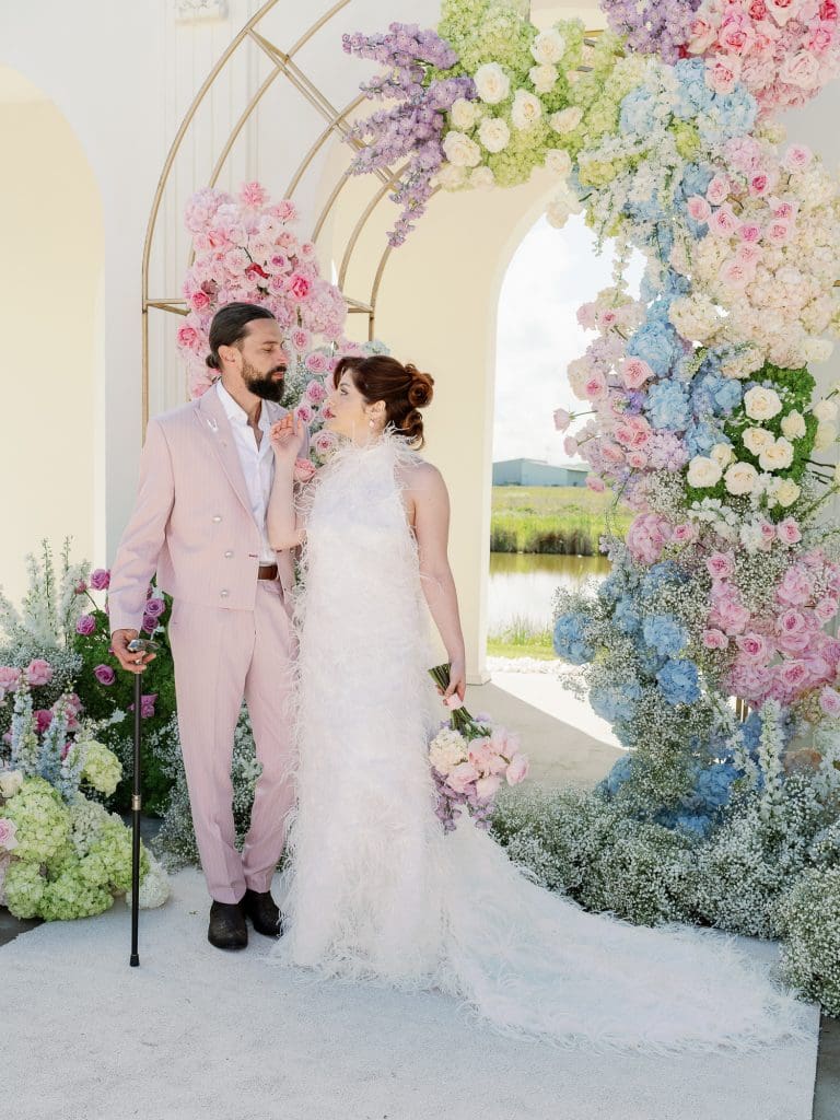 Mire și mireasă în ținute moderne la styled shoot cu arc floral colorat