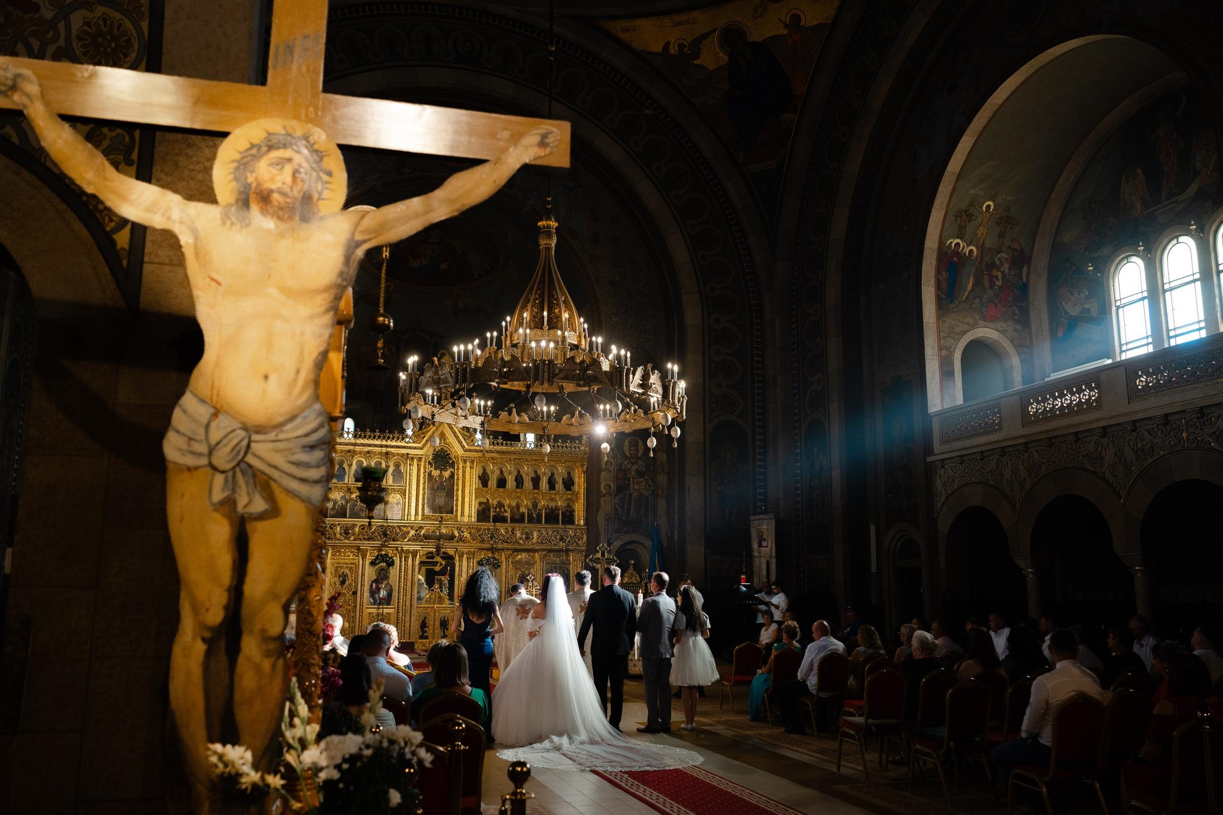 Cununie religioasă la catedrala din Orăștie, cu lumina de apus intrând prin ferestrele înalte